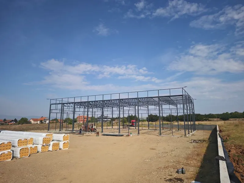 Čelična konstrukcija hale na placu, u prvom planu složeni sendvič paneli
